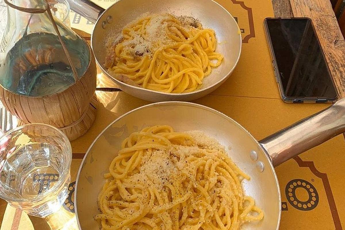 Two bowls of cacio e pepe on a cafe table in Rome