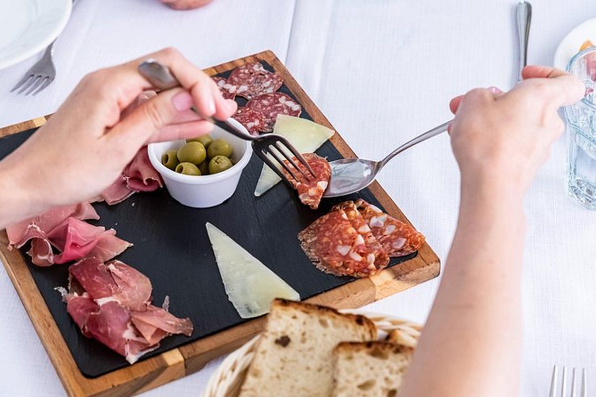 Cured meats, olives and bread on a wooden board at a Rome tasting stop