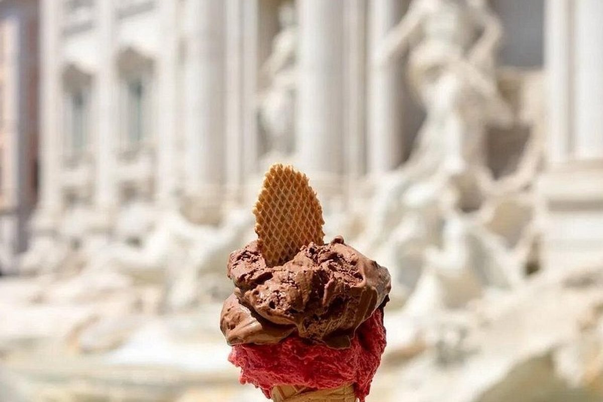 A cup of gelato in front of a Roman facade