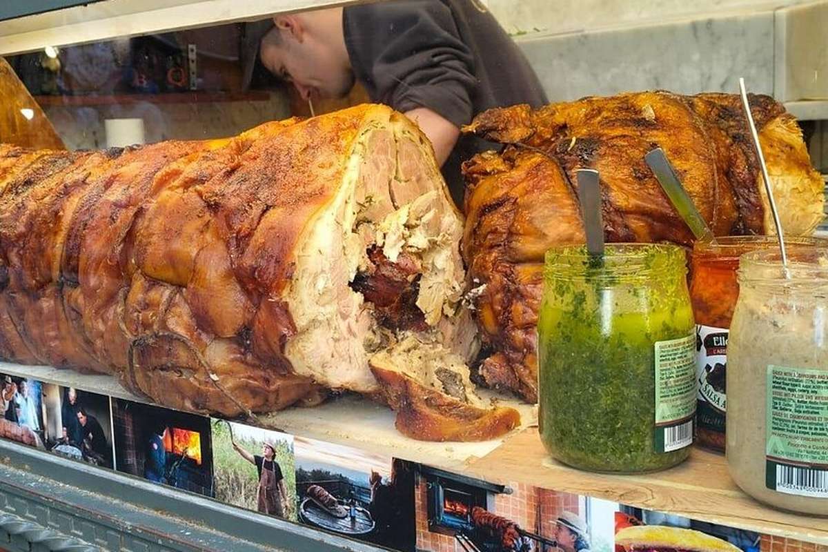 A whole porchetta on a Roman counter, ready to be sliced into a roll