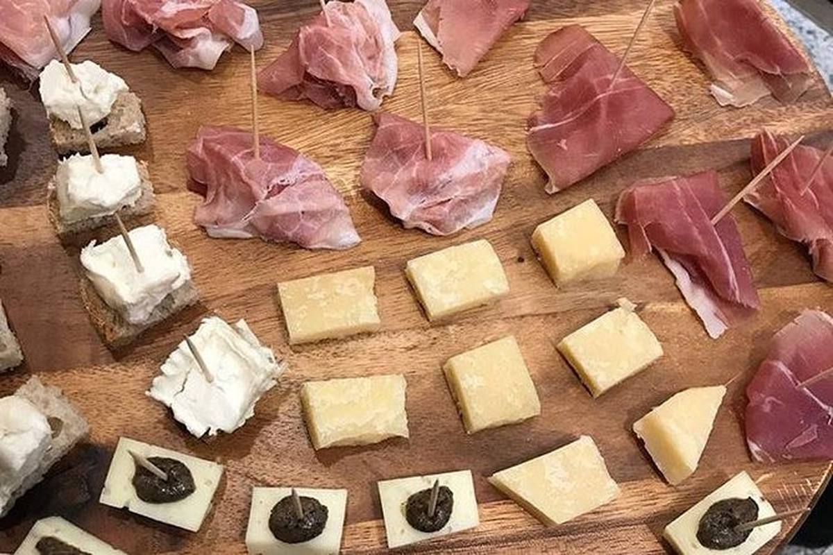 A board of Italian cheeses and cured meats laid out for a tasting