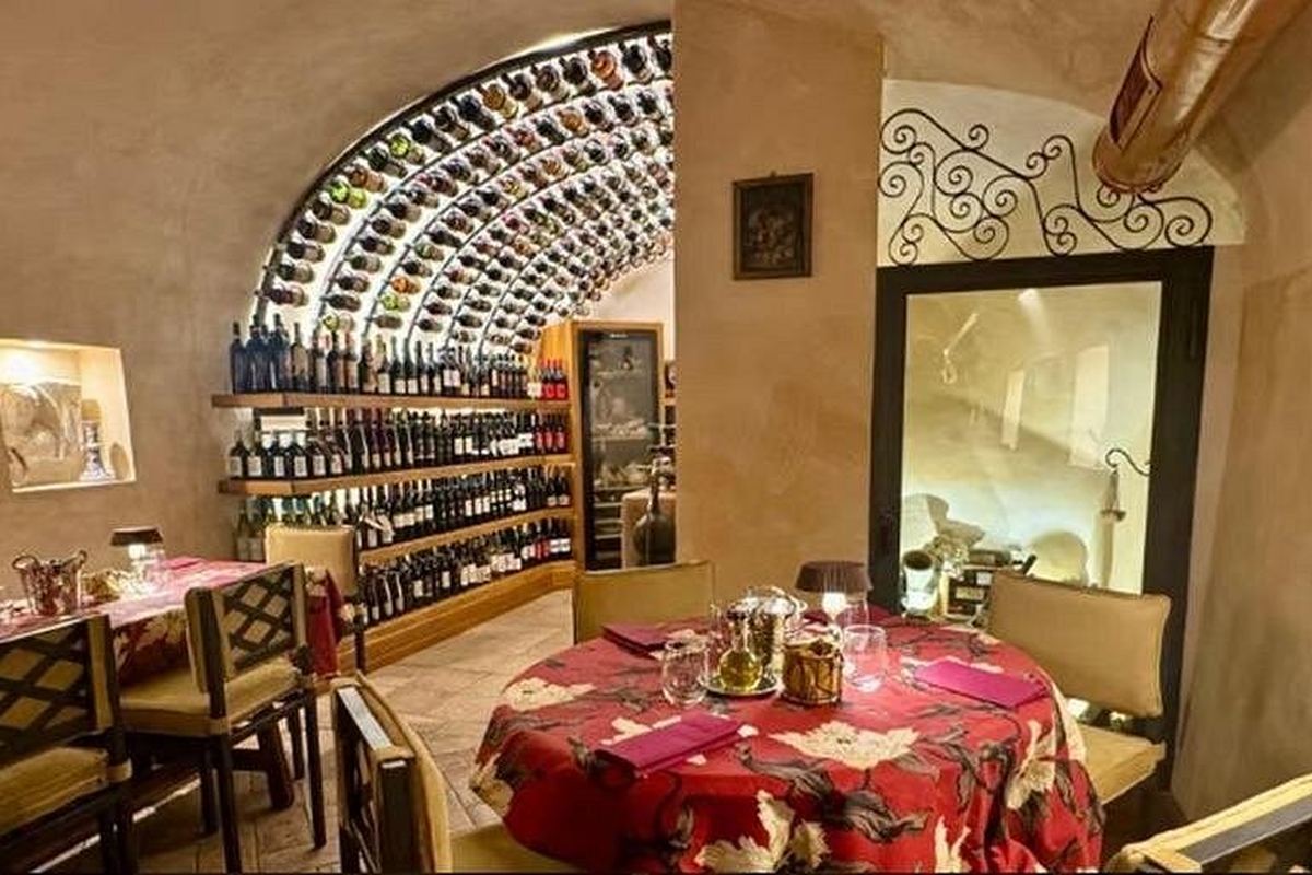 The back room of a Roman enoteca, bottles shelved in an arched alcove