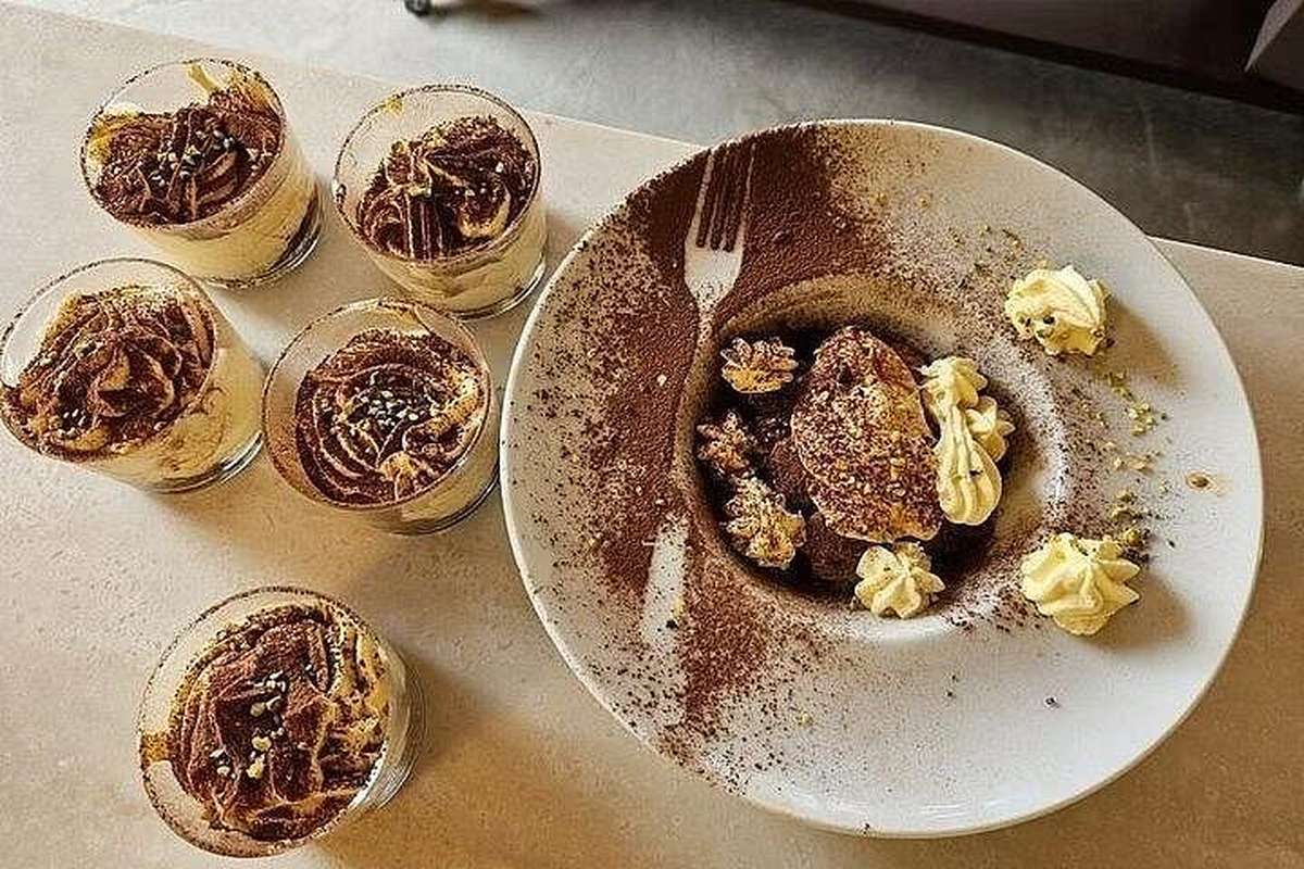 Bowls of tiramisu dusted with cocoa at the end of a Roman meal